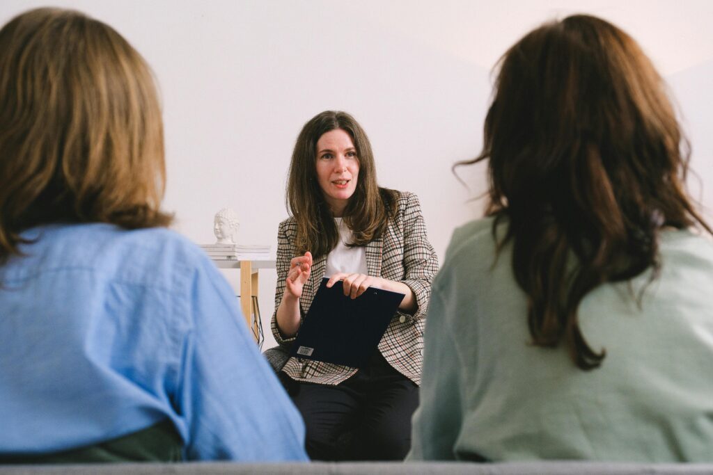 Therapist engaging in a conversation with two clients during a counseling session.